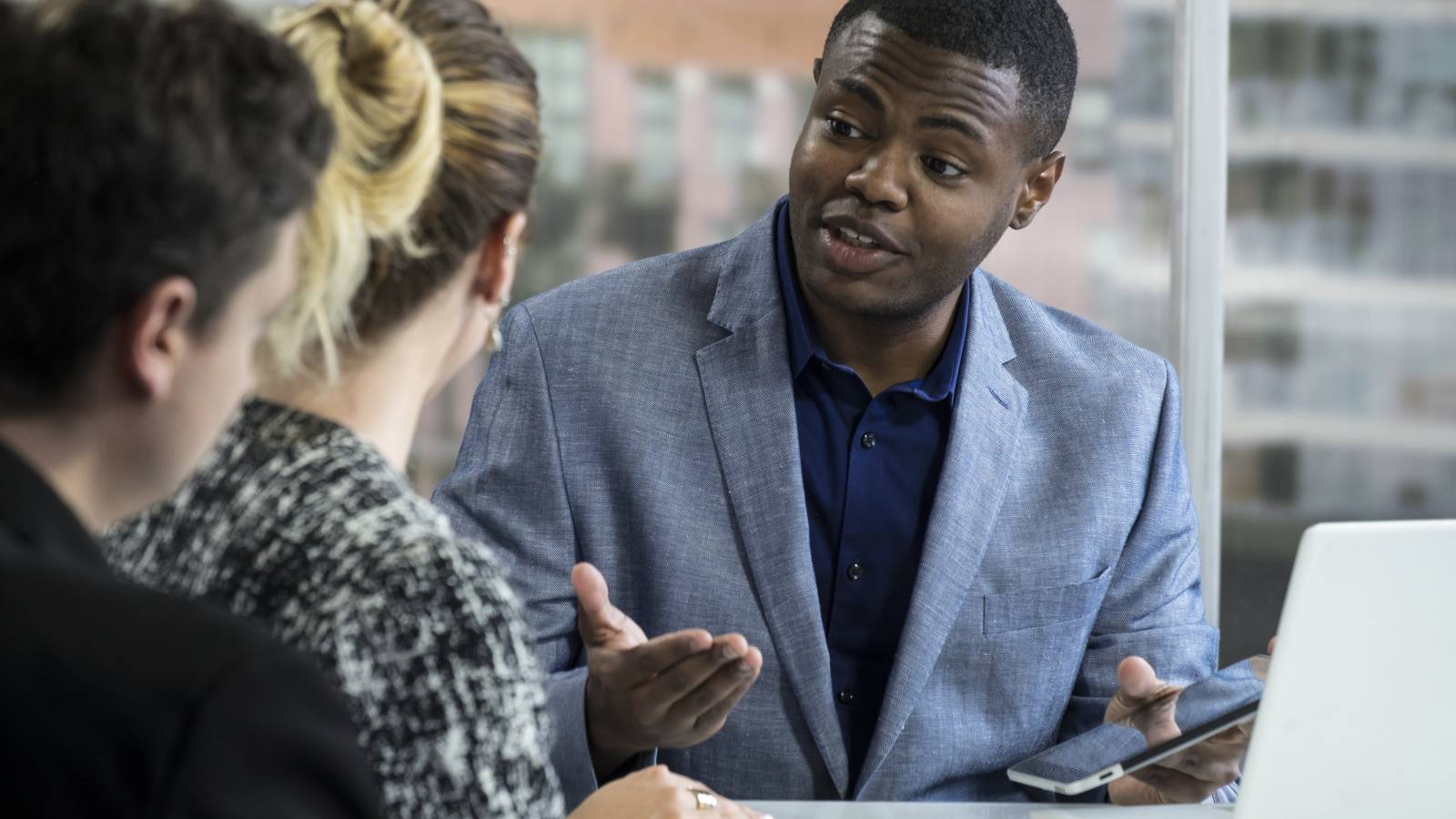 Man talking to couple with devices to illustrate preparing for presentation